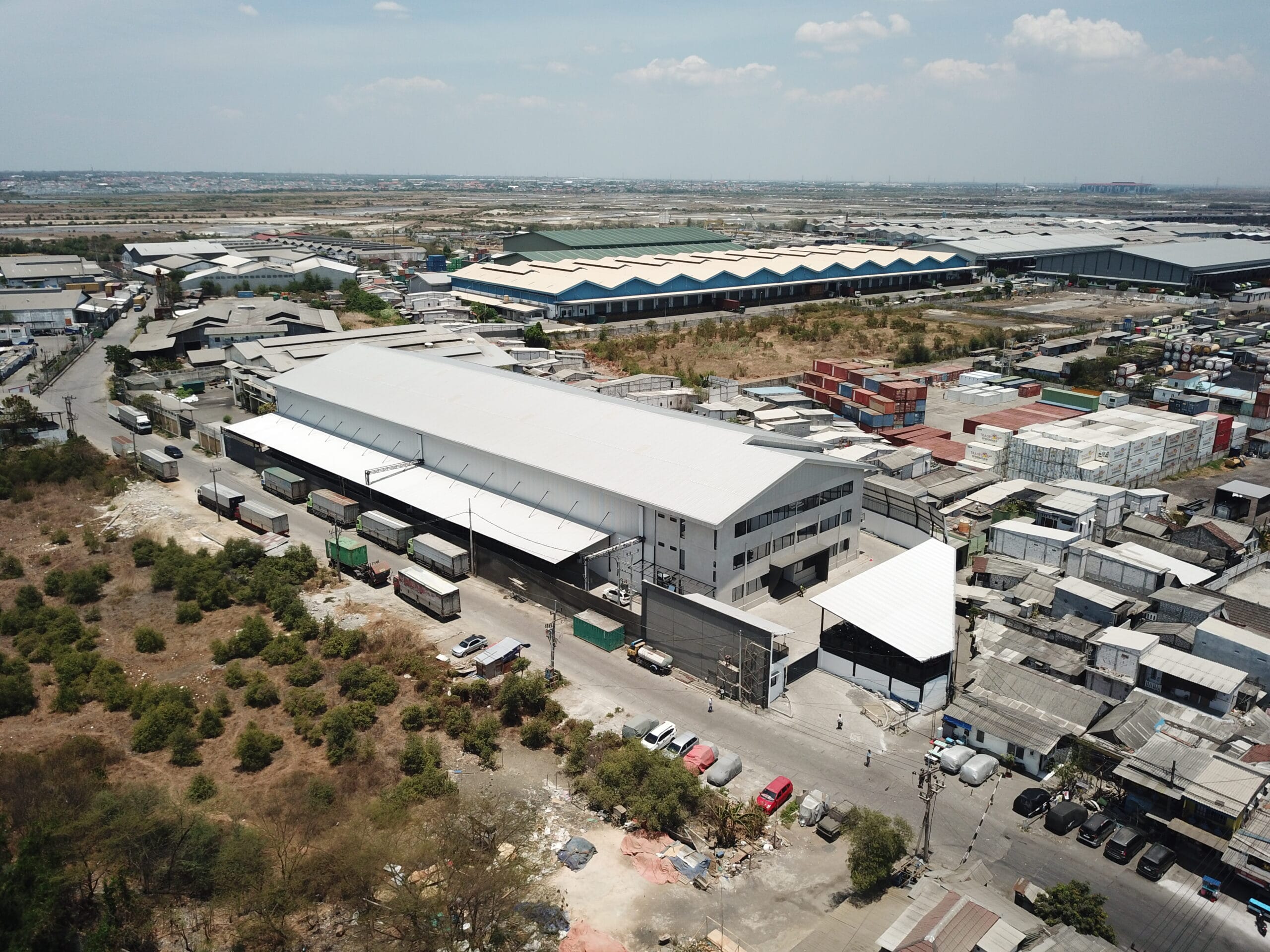 Aerial drone view of the exterior of the DSPX logistics warehouse facility in Surabaya, Indonesia.